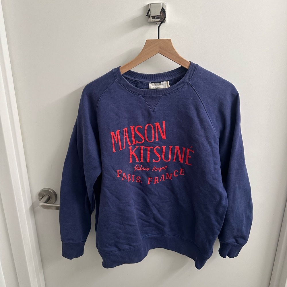 A purply blue Maison Kitsune sweatshirt with Maison Kitsune Paris, France in red